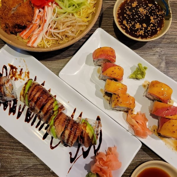 Chopstix Japanese cuisine: two plates of sushi rolls, a bowl of noodles, and a dipping sauce.